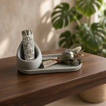 Gray handmade concrete sage holder tray with sage bundles and dried flowers for smudging rituals