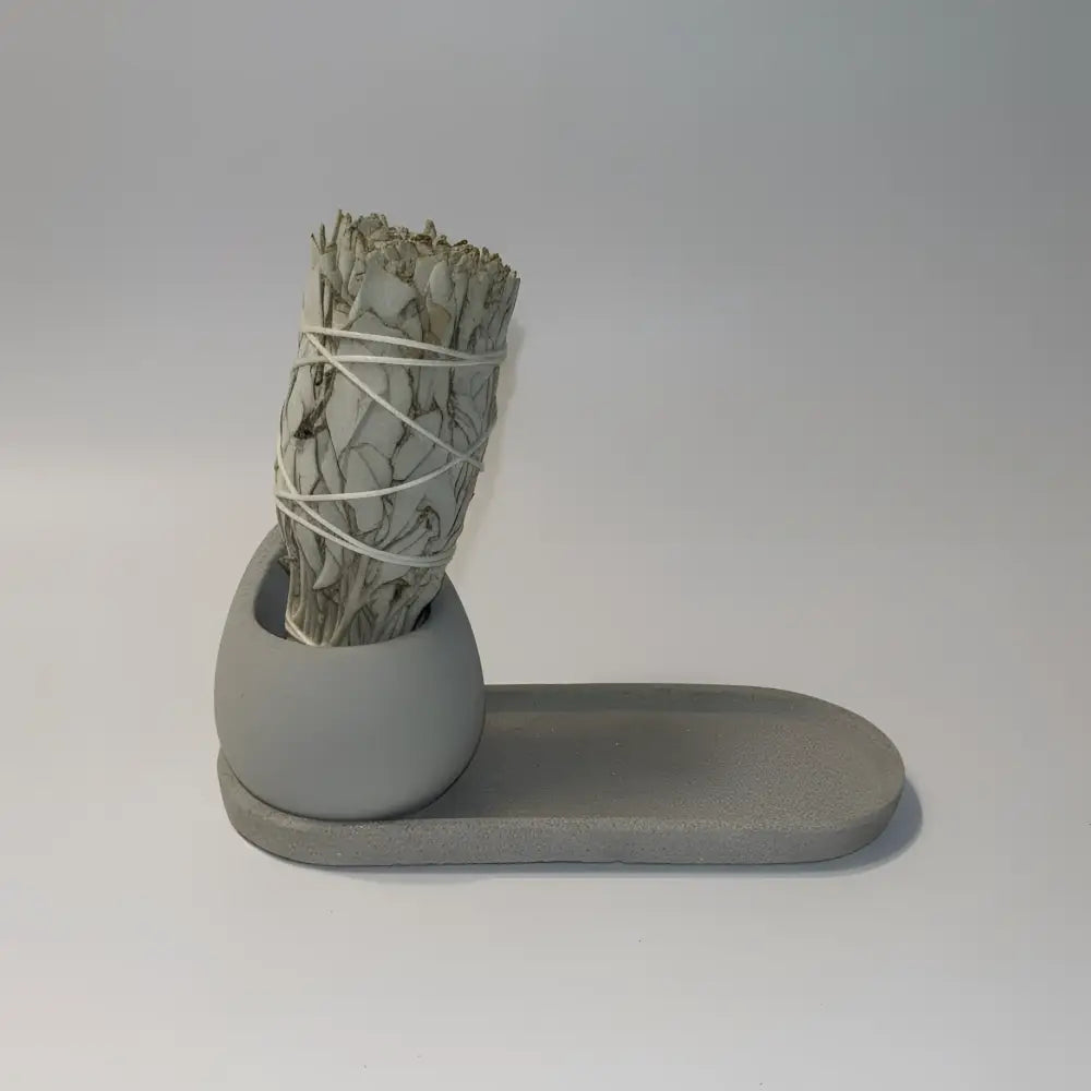 Handmade concrete sage holder with gray rounded base and sage bundle