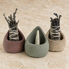 Three handmade concrete sage holders in teardrop shape each holding dried lavender sage bundles tied with twine