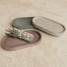 Handmade concrete small narrow trays in muted earth tones with one used as a coordinating sage holder or jewelry organizer