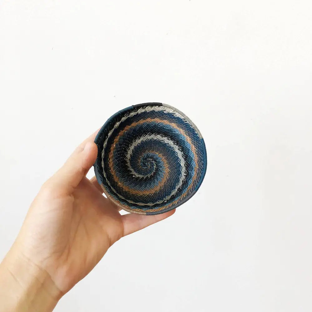 Hand-held woven basket with spiral pattern from South Africa city lights woven collection
