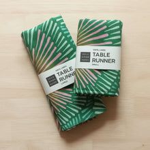 Two folded handmade eco-friendly green and pink patterned linen table runners