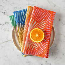 Colorful handmade eco-friendly linen napkins with sliced orange on top