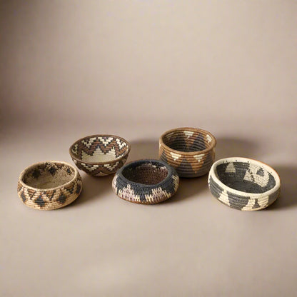 Five colorful South African woven baskets with geometric patterns in a woven basket set