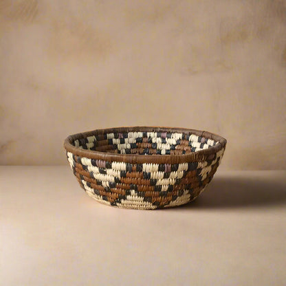 Handwoven South African woven basket with geometric pattern in brown, cream, and purple