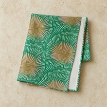 Folded handmade european linen table runner with green burst pattern and fan-like design in green and beige colors