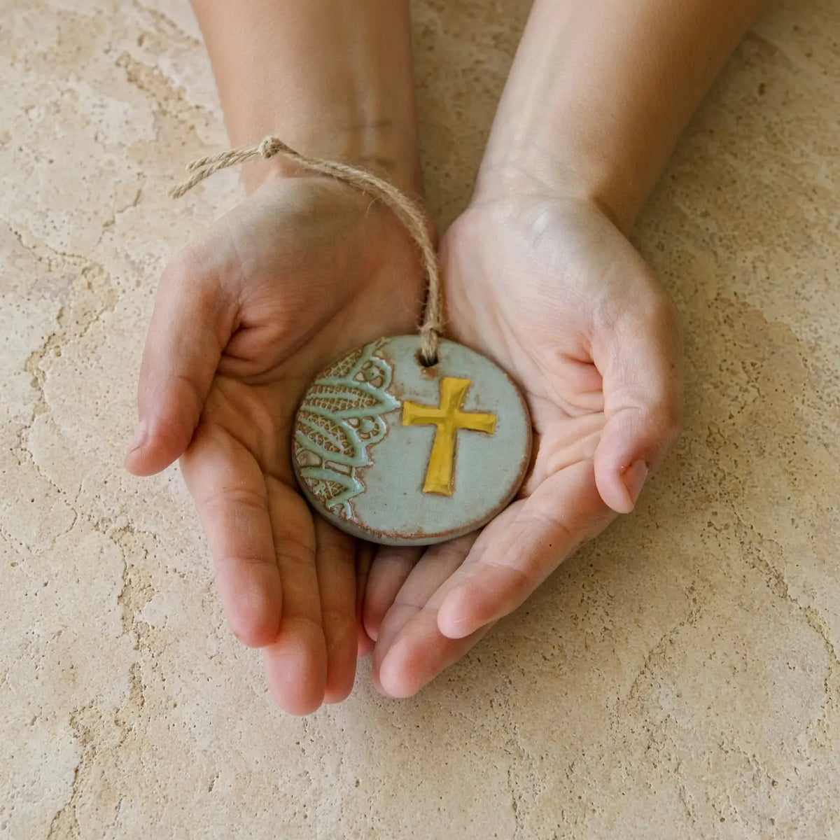 Handmade gold leaf cross ceramic ornament with matte light blue glaze and green lace detailing supports women rebuilding