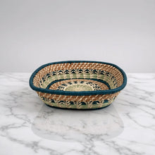 Handmade guatemalan basket with colorful leaf-patterned weave in tan cream and teal with a blue rim