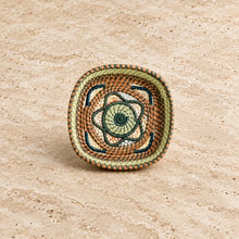 Handmade guatemalan small basket woven with a floral design in earthy brown green and cream tones