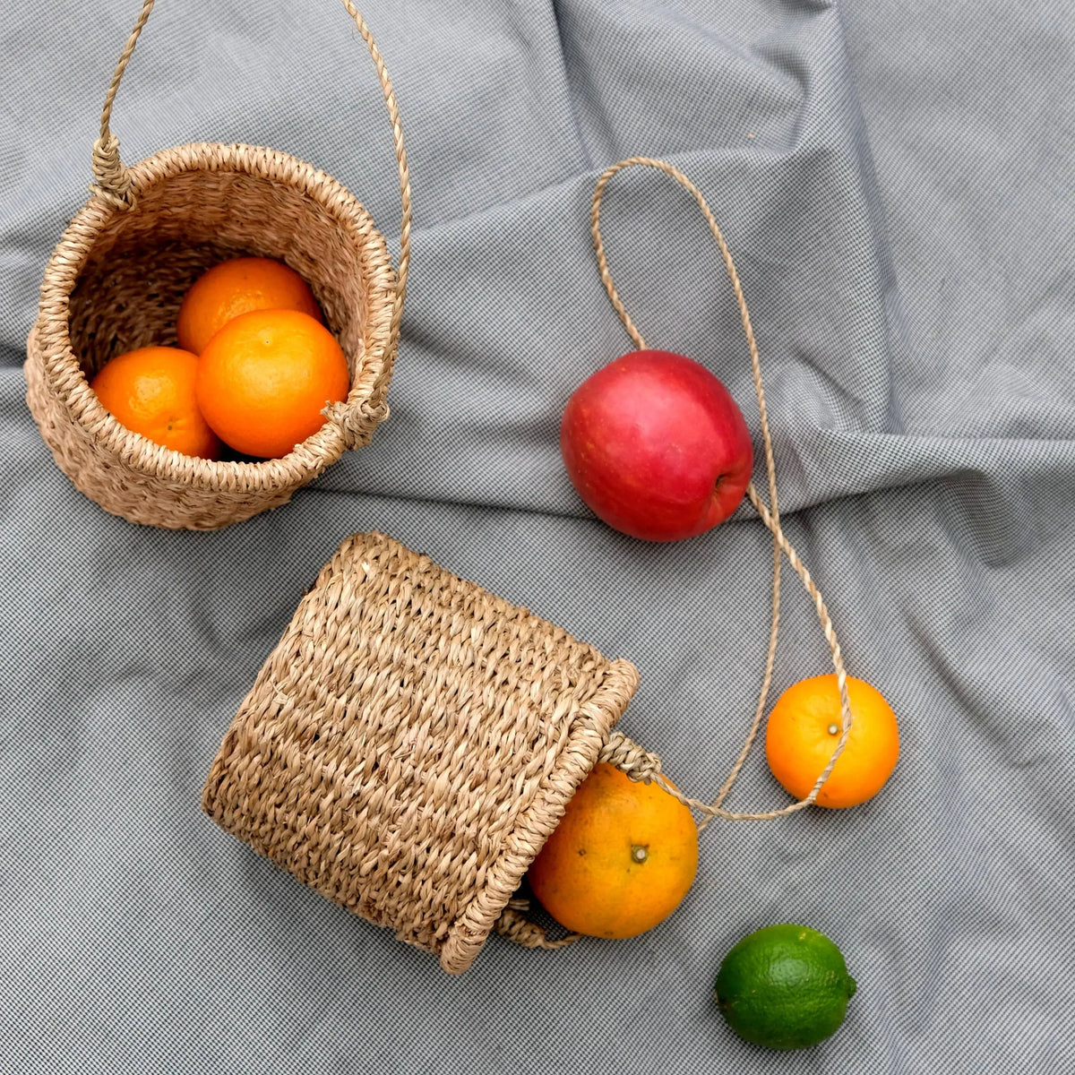 Handmade hanging basket with woven seagrass, filled with fresh fruits, perfect for decor