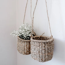 Handmade hanging seagrass basket with white flowers for a charming home decor vibe