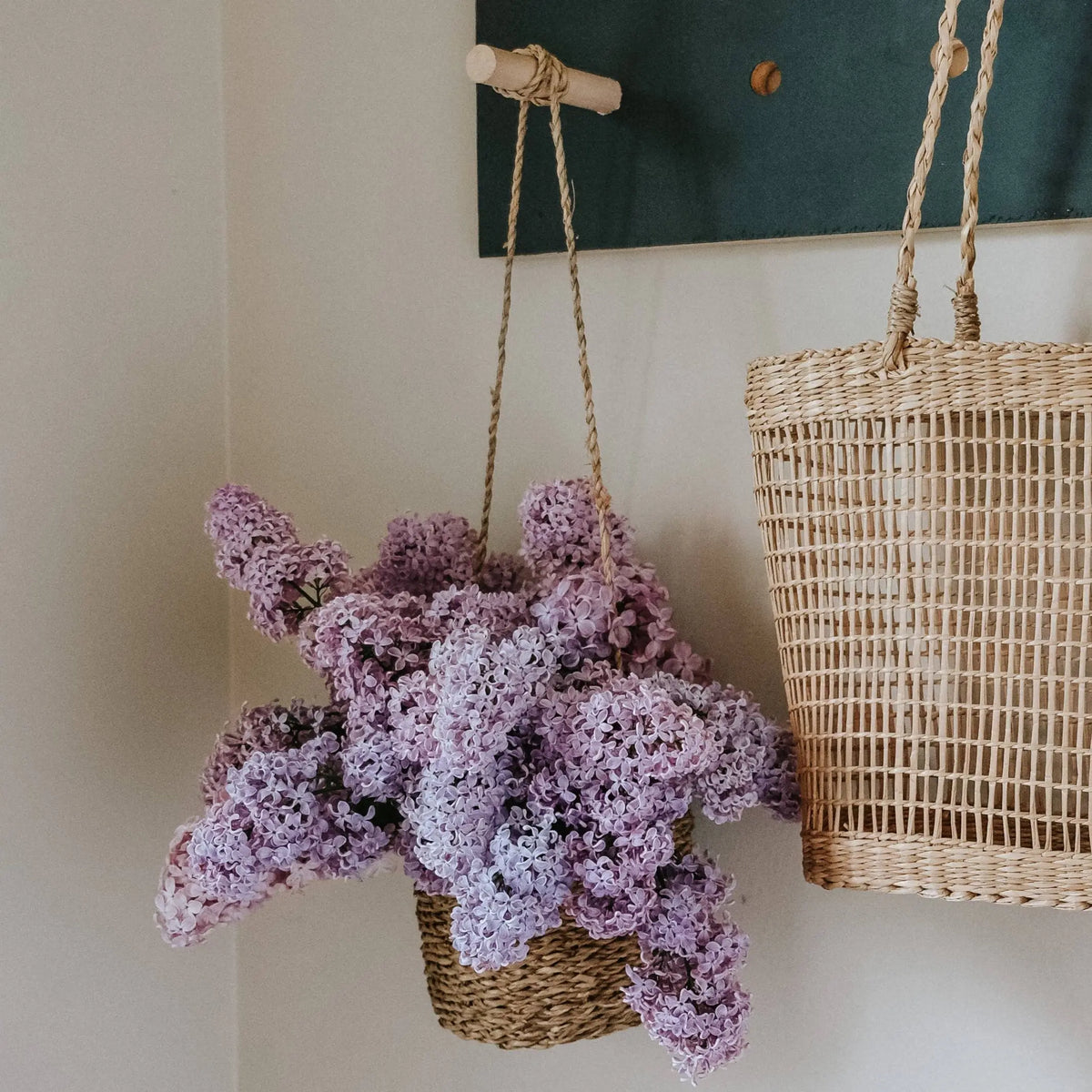 Woven hanging seagrass basket overflowing with light purple flowers, perfect handmade hanging basket