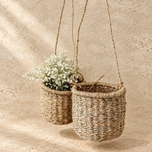 Handmade hanging basket made of beige-brown hanging seagrass with textured rope weave and braided handles