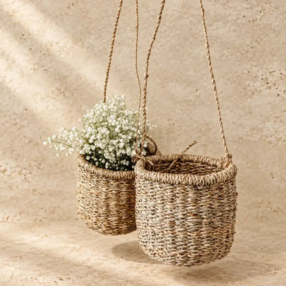 Handmade hanging basket made of beige-brown hanging seagrass with textured rope weave and braided handles