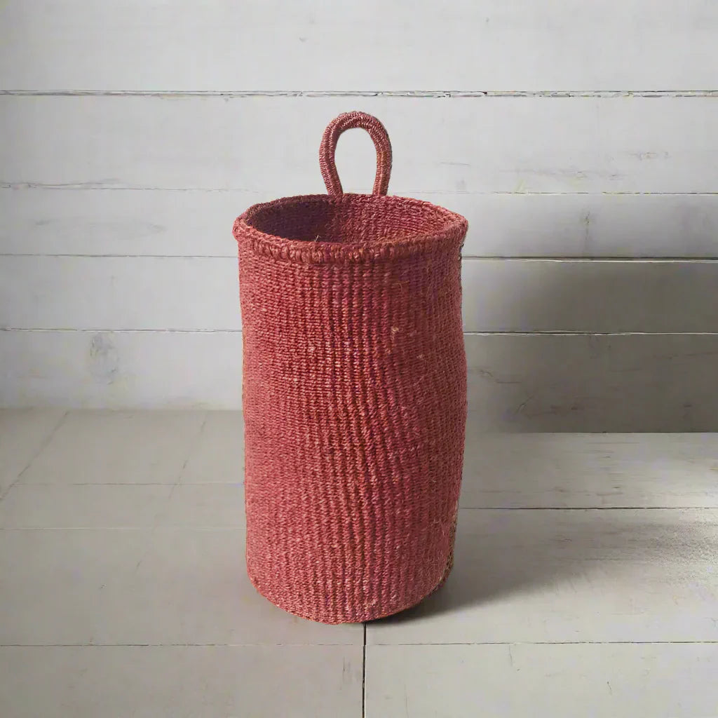 Handmade hanging sisal basket in red with a loop handle, perfect for home decor