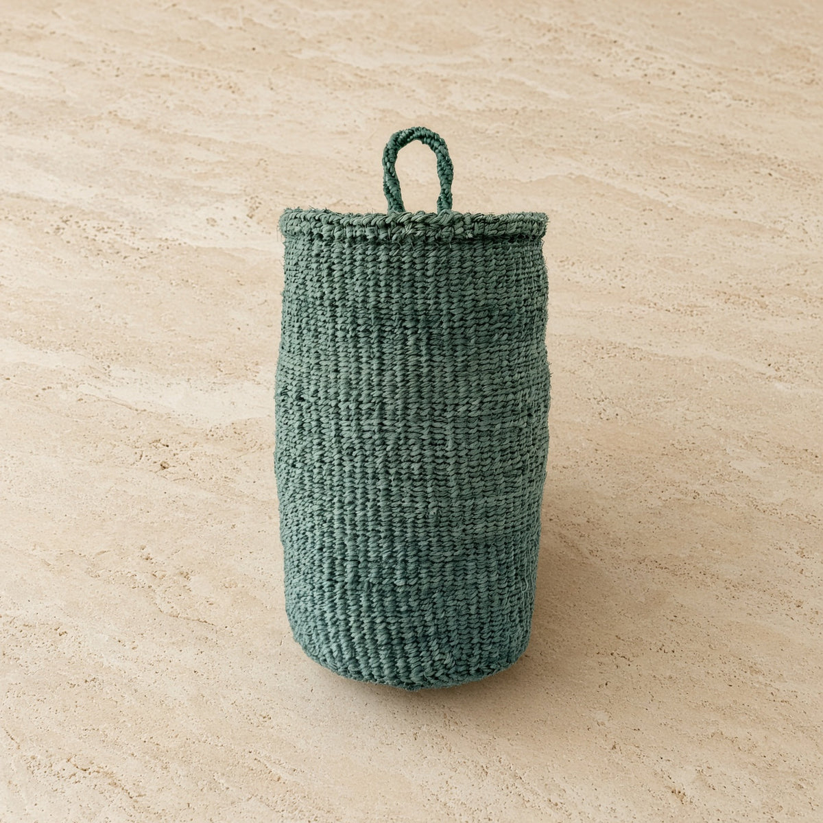 Handmade hanging sisal basket in teal with a sturdy woven pattern and looped handle for easy hanging