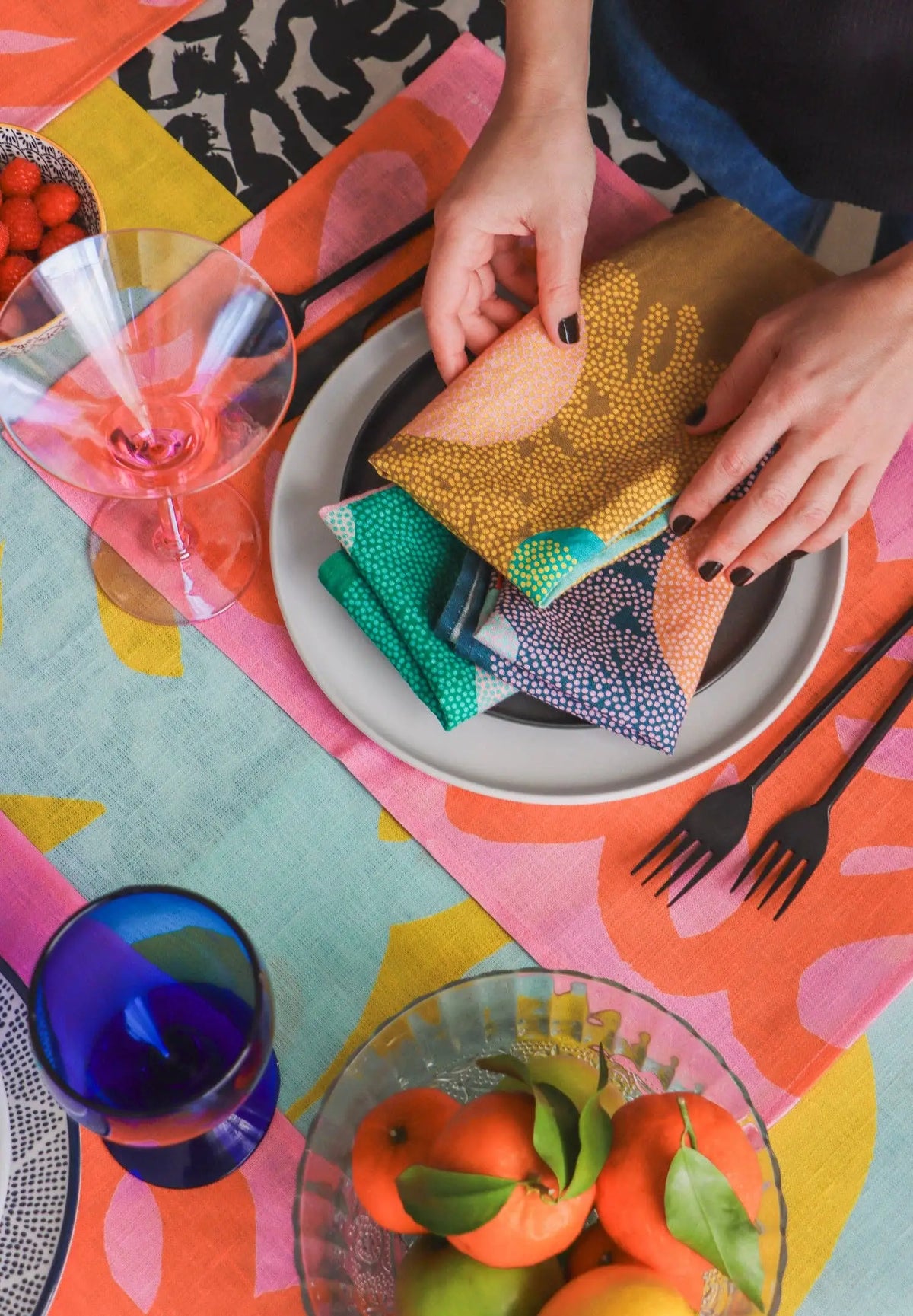 Colorful handcrafted eco-friendly linen napkins set in blue green coral yellow on a plate