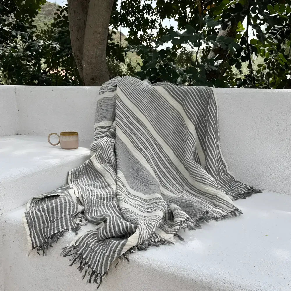 Gray and white striped muslin cotton throw blanket with fringed edges for cozy decor