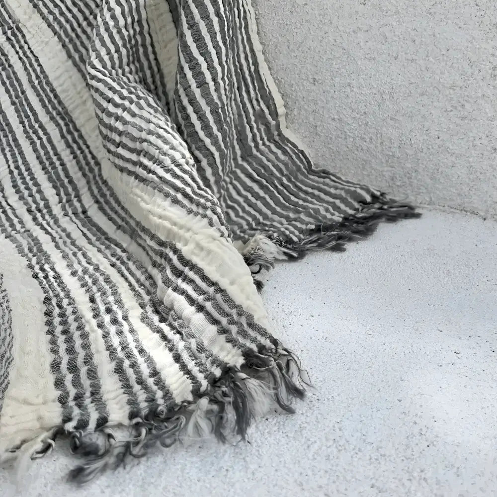 Black and white striped muslin cotton throw blanket with fringed edges for cozy style