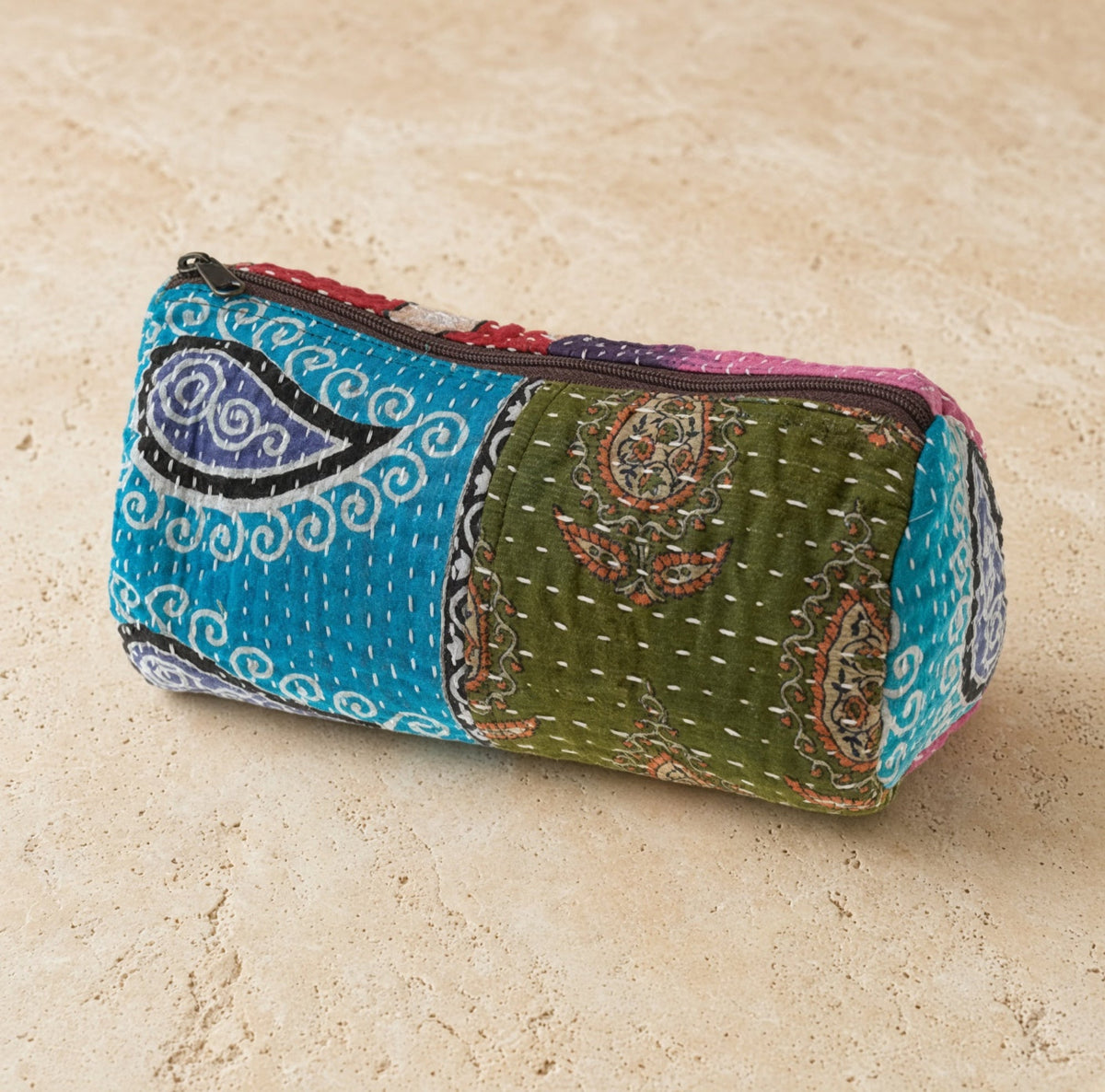 A charming handmade pouch makeup case in teal and olive green made from recycled cotton sari fabric with patchwork design