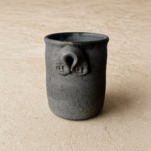 Dark gray speckled handmade pottery utensil holder with two looped handles for corralling cooking utensils