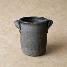 Handmade matte gray ceramic utensil holder with speckled texture and handles for corralling cooking utensils
