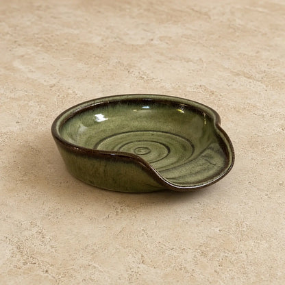 Handmade olive-green ceramic spoon rest with glossy glaze and subtle swirls perfect for spoon rest or tea strainer use