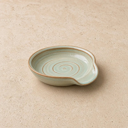 Handmade light green ceramic spoon rest with spiral pattern and rustic finish perfect for tea strainer or spoon rest use