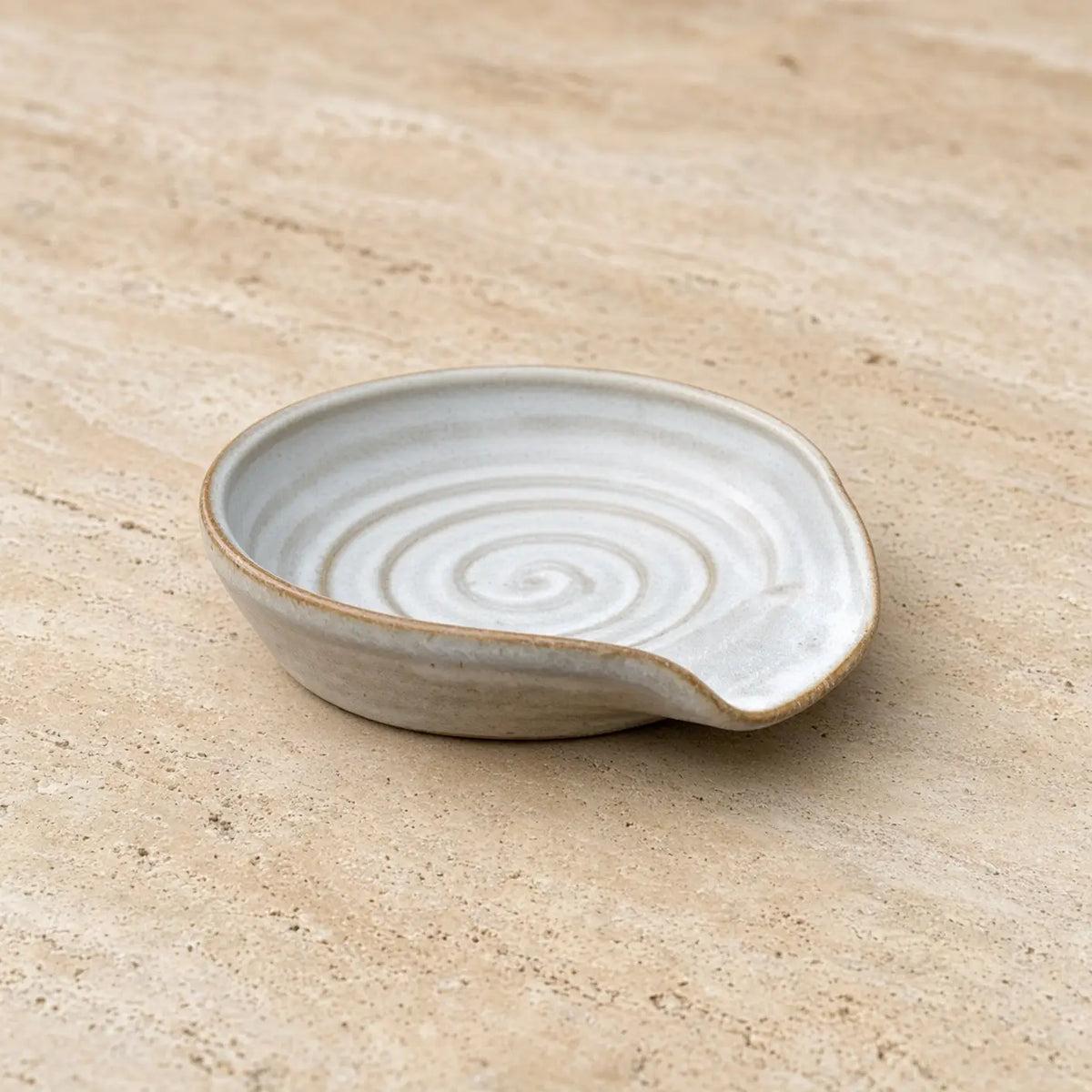 Handmade pottery spoon rest with earthy matte finish and subtle spiral pattern perfect for tea strainer or spoons