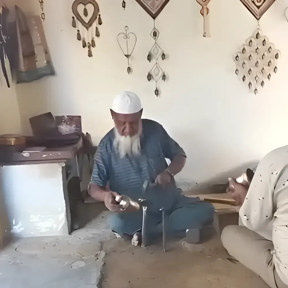 Elderly man with white beard holds cascading harmony bells with black rope