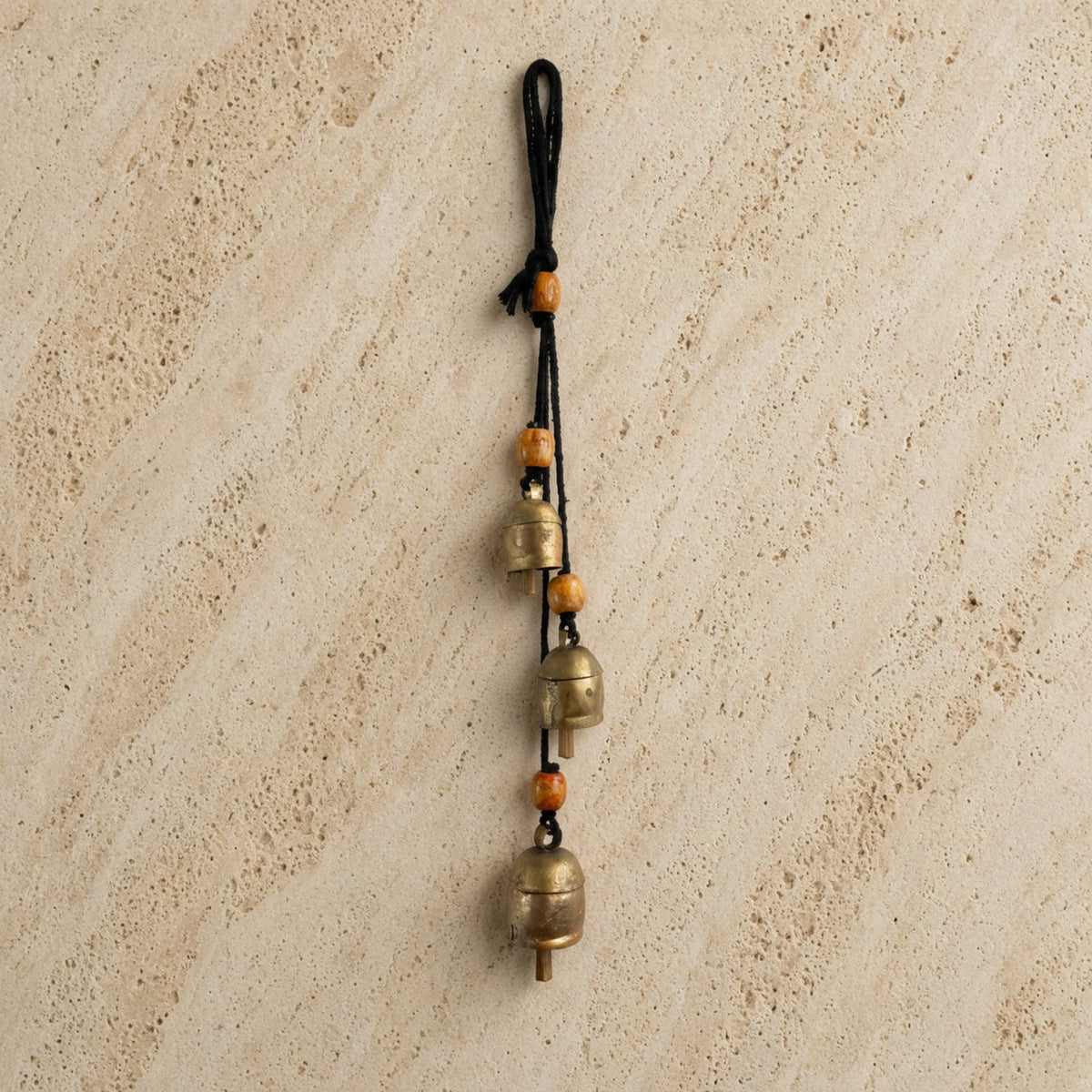 Handmade rustic cascading harmony bells with three brass bells and orange wooden beads on black cord for gentle tones