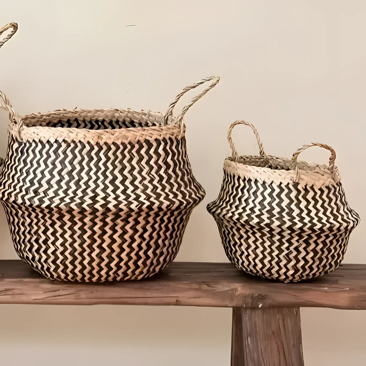 Two handmade belly baskets with black zig-zag patterns and natural handles