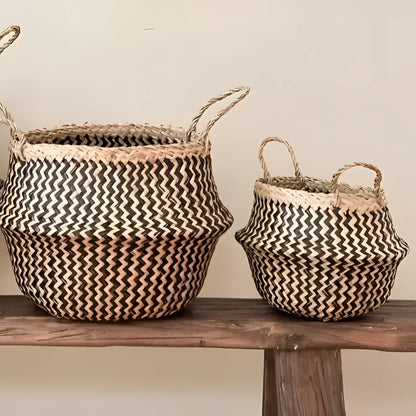 Two handmade belly baskets with black zig-zag patterns and natural handles