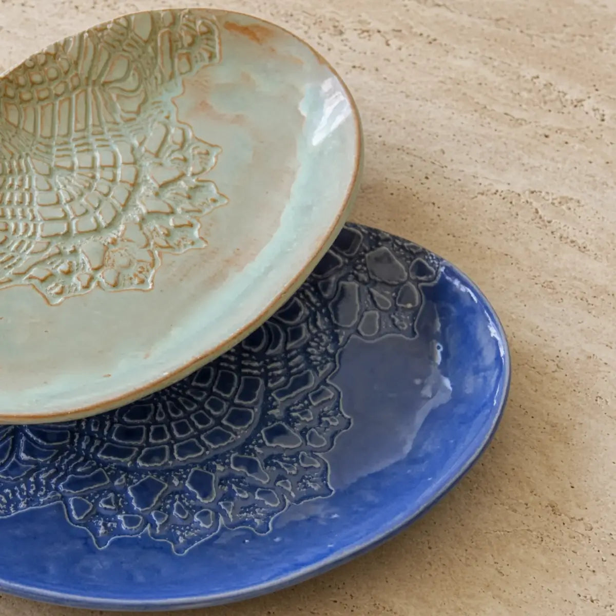 Handmade stoneware oval platters in mint green and cobalt blue with unique lace pattern ceramic dish designs
