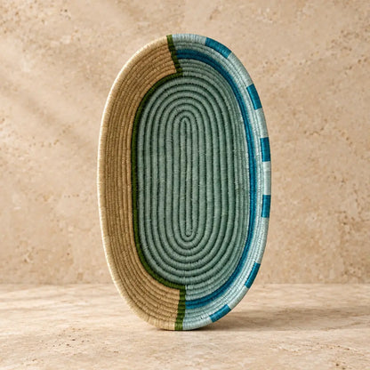 Handwoven african sisal bread basket with blue stripes featuring an oval ribbed pattern in beige sage green and teal blue perfect for serving organizing essentials