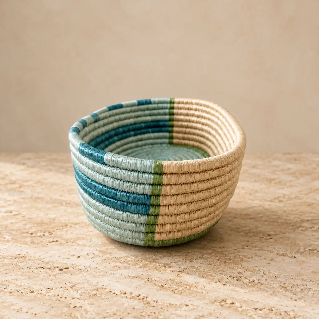 Handwoven african sisal bread basket with natural beige base and vibrant teal blue green stripes for serving organizing essentials