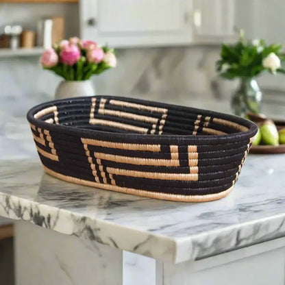 Black and tan woven oval sisal bread basket with geometric patterns by skilled artisans