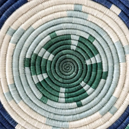 Handwoven african sisal trivet with geometric stars in green blue and cream circular design