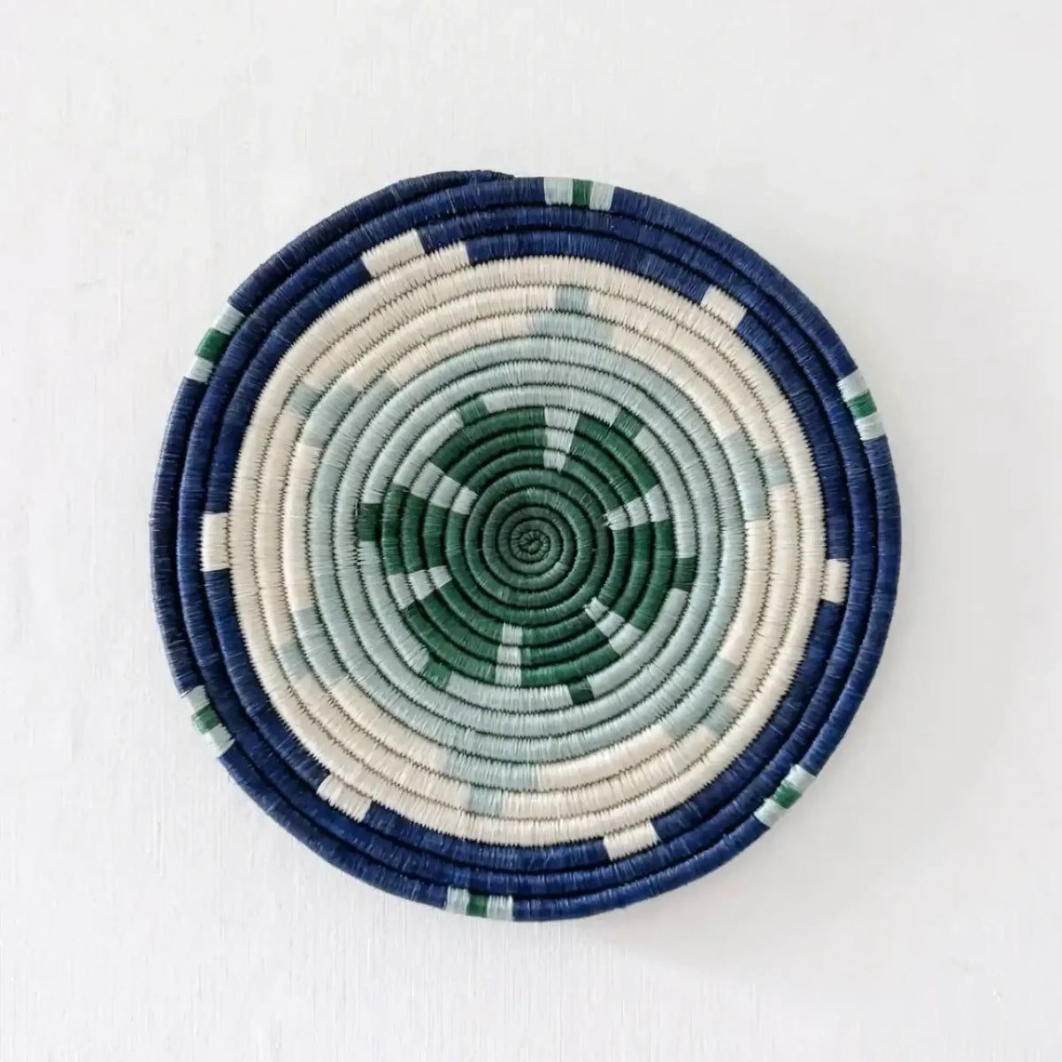 Handwoven african sisal trivet with geometric stars pattern in navy blue cream and green concentric rings