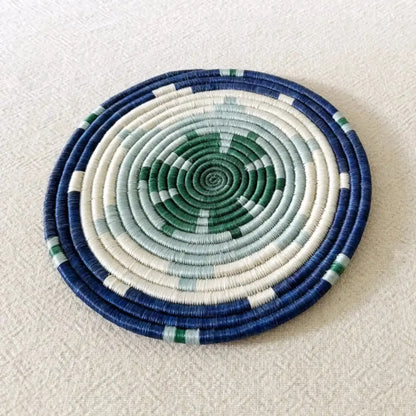 Handwoven african sisal trivet with geometric stars in navy blue cream and green concentric rings