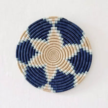 Circular handwoven african sisal trivet with navy beige and mint green concentric spirals for stylish use