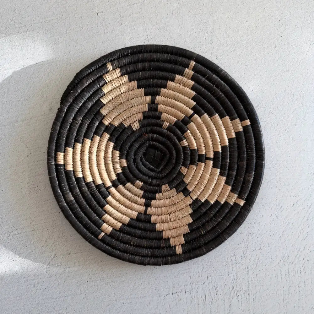 Handwoven african zulu trivet in black and beige made from ilala palm and wild grasses from south africa with spiral pattern