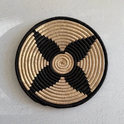 Handwoven african zulu trivet in black and beige woven from ilala palm and wild grasses featuring a spiral pattern from south africa