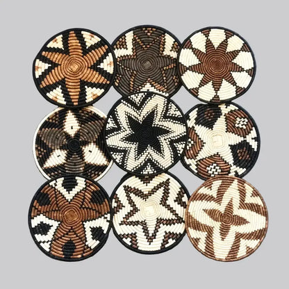 Handwoven african zulu trivet with black star pattern made from ilala palm and wild grasses in natural brown cream colors