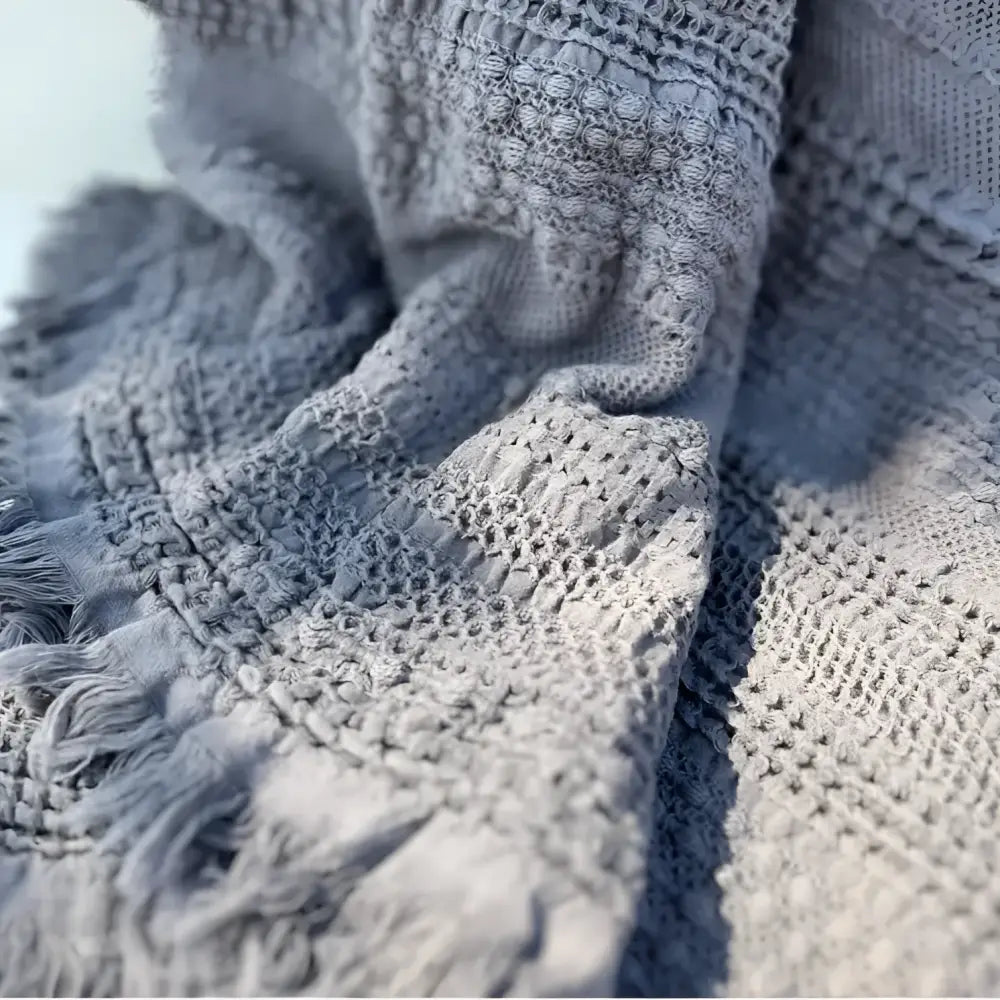 Textured light gray handwoven waffle bed blanket with fringe for cozy comfort