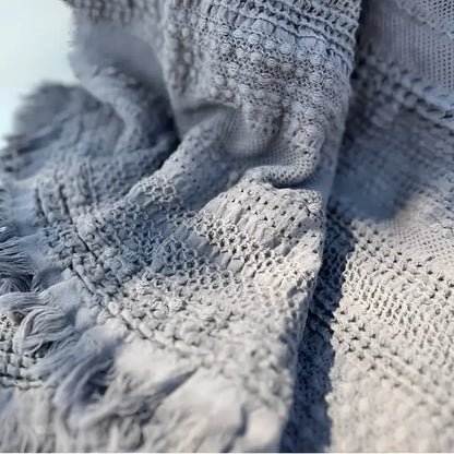 Textured light gray handwoven waffle bed blanket with fringe for cozy comfort
