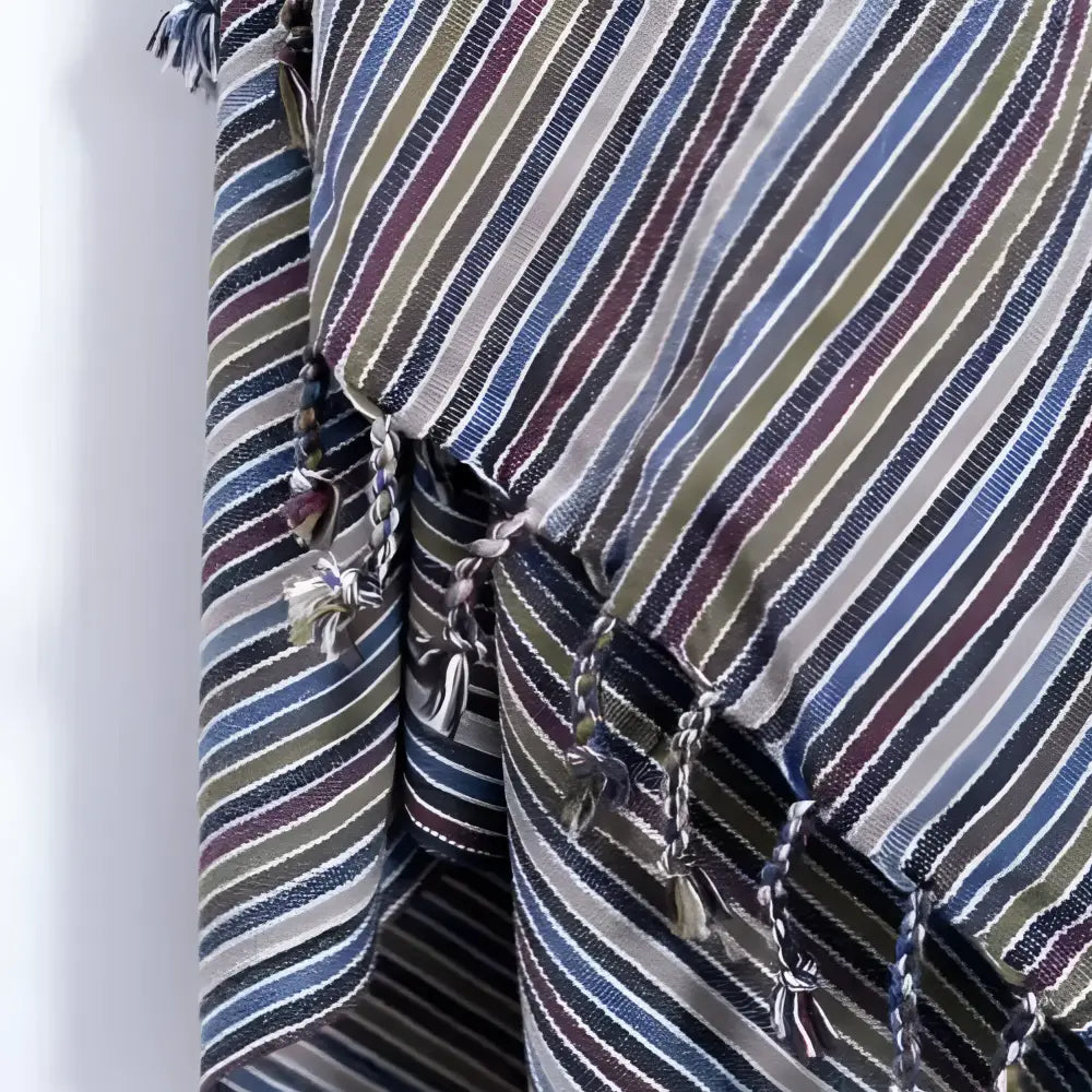 A handwoven earthy striped turkish hand towel with diagonal blue green beige and burgundy stripes and tassels