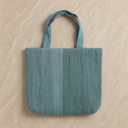 Teal handwoven ethiopian cotton tote bag with ribbed texture and matching handles featuring button closure