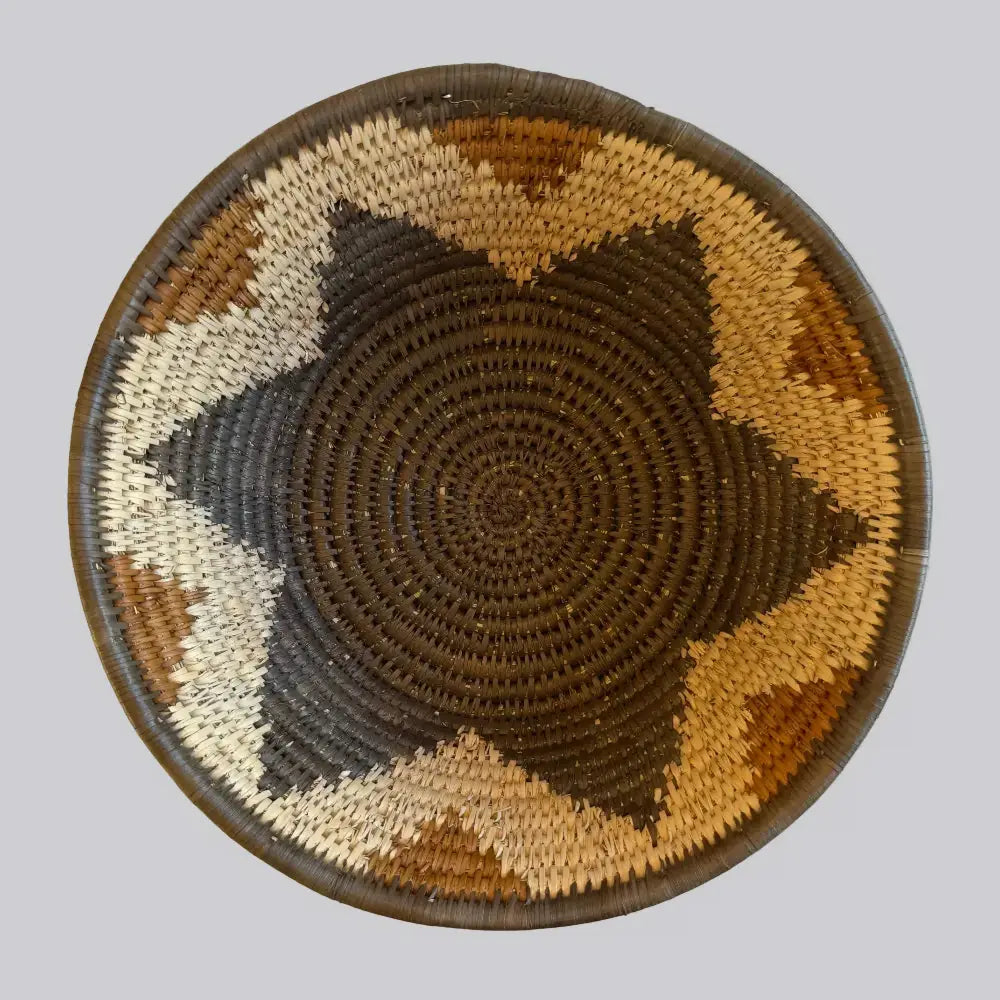 Handwoven large african zulu bowl with starburst pattern in earthy tones made from sustainably sourced ilala palm south africa