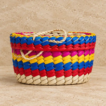 Vibrant handwoven Mexican palm tortilla basket with blue red yellow and pink stripes and a natural handle for taco night
